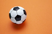 迷你足球在一个橙色的表面与复制空间