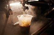 热浓缩咖啡倒入加冰的杯子