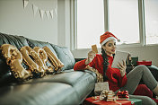 美丽的女人庆祝圣诞节和购物的圣诞礼物在网上在家