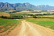 南非西开普省美丽的农田、乡村建筑和远处参差的山脉