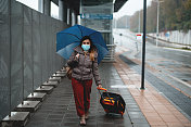 一名年轻女子在公共汽车站戴着防护口罩