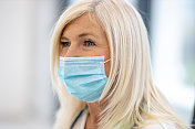 一位戴着听诊器和防护面罩的资深女医生的肖像