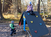 一个孩子，一个3岁的白人男孩和一个5岁的女孩在操场上玩得很开心。孩子们爬上孤儿院。