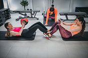 两个运动的年轻女人一起在健身房运动球