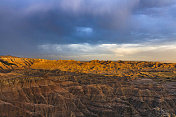 太阳在乌云下的沙漠峡谷上落下