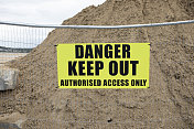禁止进入的标志在金属栅栏前面的一堆沙子