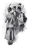 三个游客在聊天，其中一个拿着一根棍子，上面挂着一个背包