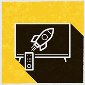 电视与火箭。图标与长阴影的纹理黄色背景