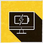 带电池充电符号的台式电脑。图标与长阴影的纹理黄色背景