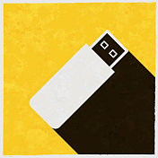 USB闪存驱动器。图标与长阴影的纹理黄色背景