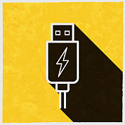 USB充电插头。图标与长阴影的纹理黄色背景