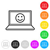 笔记本电脑上有快乐的表情。彩色按钮上的图标 笔记本电脑上有快乐的表情。彩色按钮上的图标