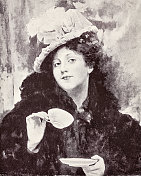 戴着帽子的年轻女子正在喝茶