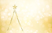 创意闪闪发光的金色米色的空白空白水平节日圣诞背景与一个抽象的轮廓闪闪发光的金属浅棕色圣诞树像一个闪烁的星星在其顶部和复制空间的文字在右侧