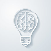 有大脑的灯泡。空白背景上剪纸效果的图标