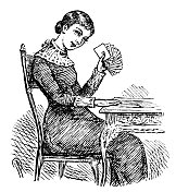 年轻女子坐在桌旁，手里拿着扑克牌