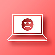 带有悲伤表情的笔记本电脑。图标在红色背景与阴影