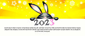 2023年庆祝新年和圣诞节的概念。黑色的兔子在一个抽象的彩色背景与一个地方的文字。