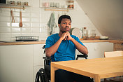 一个年轻的非裔美国人坐在轮椅上感到沮丧