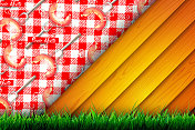卡通风格的野餐月节日贺卡。在一个阳光明媚的日子里，在年轻的草地的背景下，红白格子野餐毯上的木板和一根热狗棒。