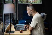 一个随意的自由企业家在笔记本电脑上工作的肖像