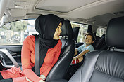 一名穆斯林妇女开车送儿子上学，
