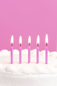 粉红色的生日蜡烛放在蛋糕上