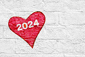 文本2024年新年在一个红色的心在白色砖墙粗糙质朴的矢量背景