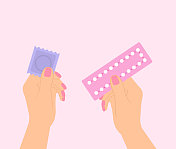 女性手持避孕药和避孕套，背景为粉红色。选择避孕方法