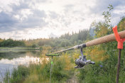 钓竿竖立在抛入水中用于钓鱼的支撑物上的钓竿
