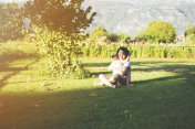 母亲抱着女儿坐在绿草地上