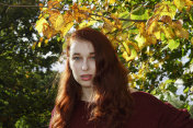 秋天的户外女孩红头发与黄叶的椴树