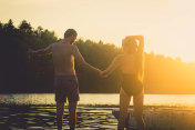 年轻浪漫的夫妇在湖边欣赏日落