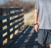 在阳光明媚的日子里，成年男性戴着健身追踪器在户外散步