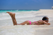 美丽的女人享受躺在沙滩上
