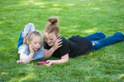 孩子们在草坪上看手机视频