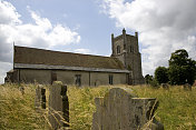 有杂草丛生的墓地的英国乡村教堂
