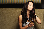 年轻女子在酒吧喝葡萄酒