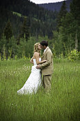新娘和新郎在浪漫的山草地接吻