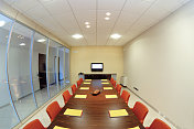 会议室，红椅子，木桌和内部玻璃墙