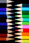 不同颜色的铅笔在黑色的表面