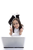 年轻女孩在笔记本电脑上打字，微笑着竖起大拇指