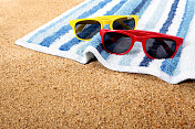 海滩浴巾上戴着太阳镜