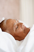 一个上了年纪的女人躺在床上的特写