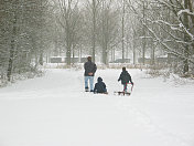 一个男人和孩子们在雪地里拉着雪橇