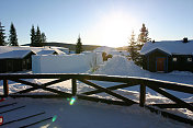 太阳从雪中的小屋升起