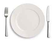 晚餐用白色的盘子，刀叉放在白色的背景上