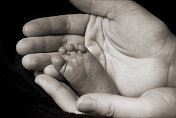 新生儿的脚在父母的手中