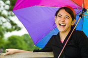 十几岁的女孩笑着拿着五颜六色的伞