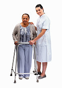 护士在帮一位老妇人扶助步器